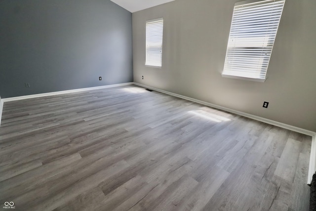 spare room featuring baseboards and wood finished floors