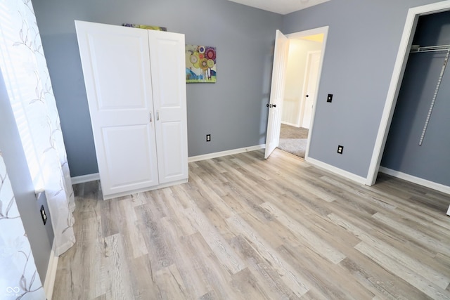 unfurnished bedroom with light wood-type flooring and baseboards
