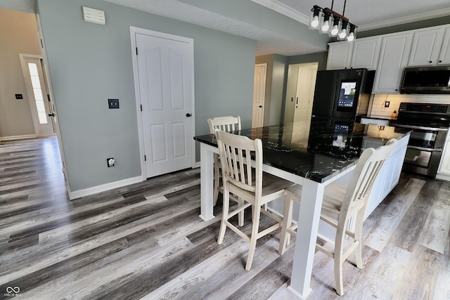 kitchen featuring stainless steel appliances, white cabinets, dark wood-style floors, decorative backsplash, and crown molding
