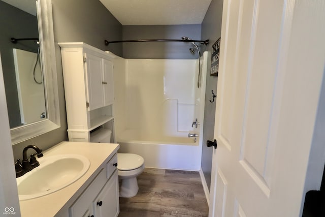 full bath with wood finished floors, toilet, vanity, and shower / washtub combination
