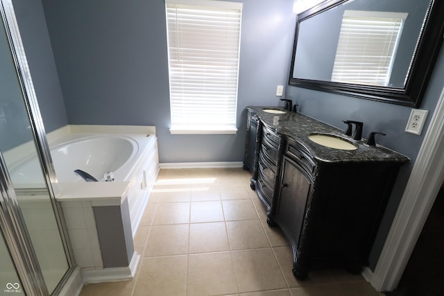 bathroom with baseboards, tile patterned floors, double vanity, a garden tub, and a shower with shower door