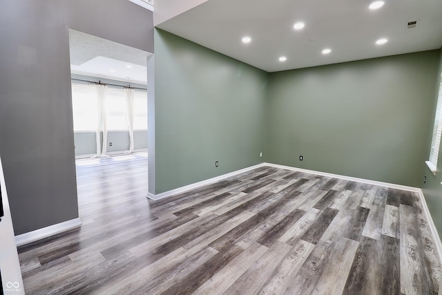 unfurnished room featuring wood finished floors, baseboards, and recessed lighting