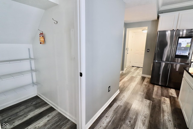 corridor with dark wood-type flooring and baseboards