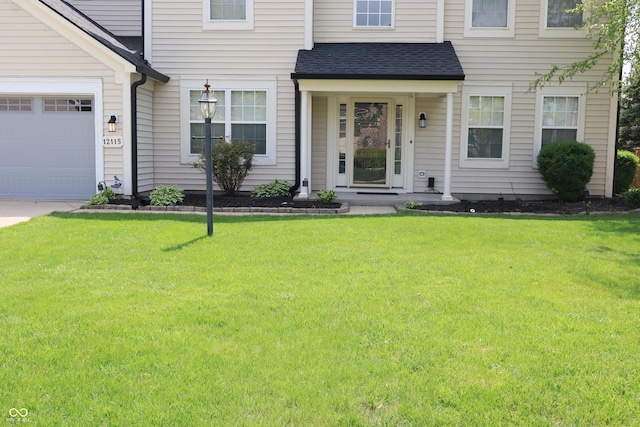 view of front of home featuring a shingled roof, a front yard, a garage, and driveway