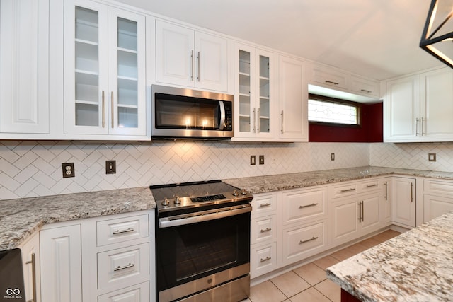 10713 Stable Dr, Indianapolis, IN 46239 - kitchen featuring appliances with stainless steel finishes, tasteful backsplash, white cabinets, light tile patterned floors, and light stone counters