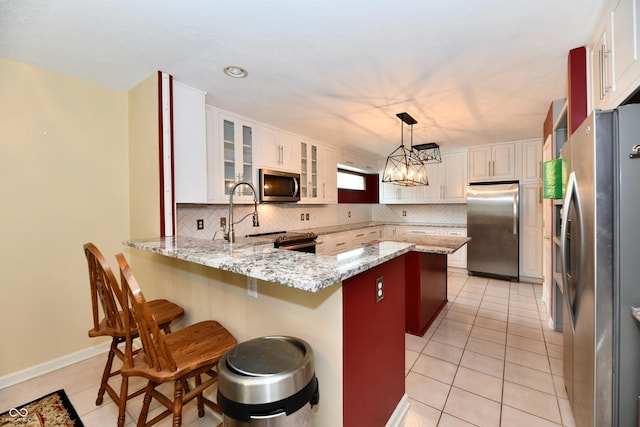 10713 Stable Dr, Indianapolis, IN 46239 - kitchen featuring stainless steel appliances, a peninsula, backsplash, light tile patterned flooring, and light stone counters