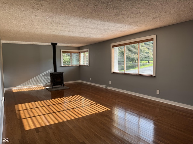 7897 Moore Rd, Indianapolis, IN 46278 - unfurnished living room with a wood stove, baseboards, a textured ceiling, healthy amount of natural light, and wood finished floors