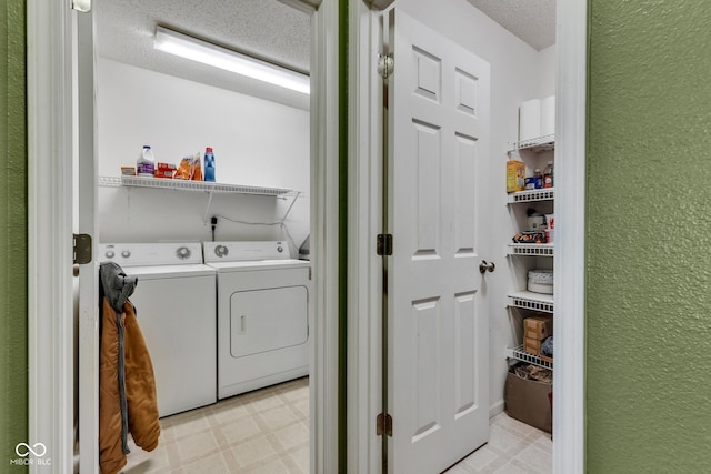 laundry area with separate washer and dryer, a textured ceiling, light flooring, and a textured wall