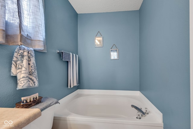 bathroom with a bath and a textured ceiling