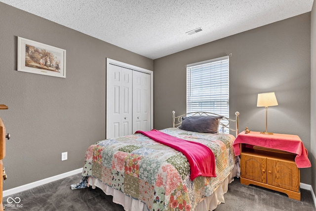 carpeted bedroom with a closet, baseboards, and a textured ceiling