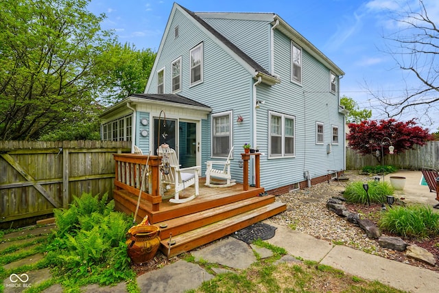 rear view of property featuring a deck and a fenced backyard