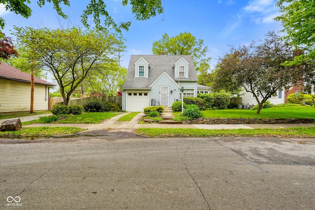 cape cod-style house with a garage, aphalt driveway, a front lawn, and fence