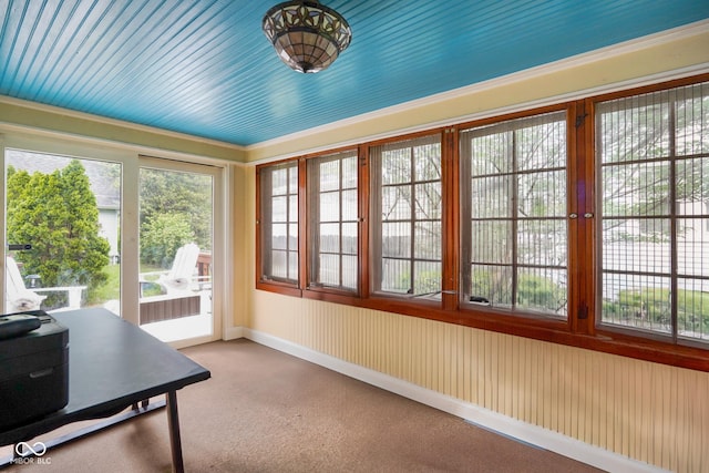 sunroom featuring a wealth of natural light, baseboards, and carpet