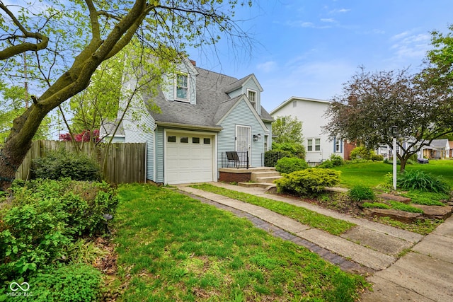 view of front of property featuring roof with shingles, fence, an attached garage, driveway, and a front lawn