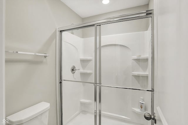full bathroom with toilet and a shower stall