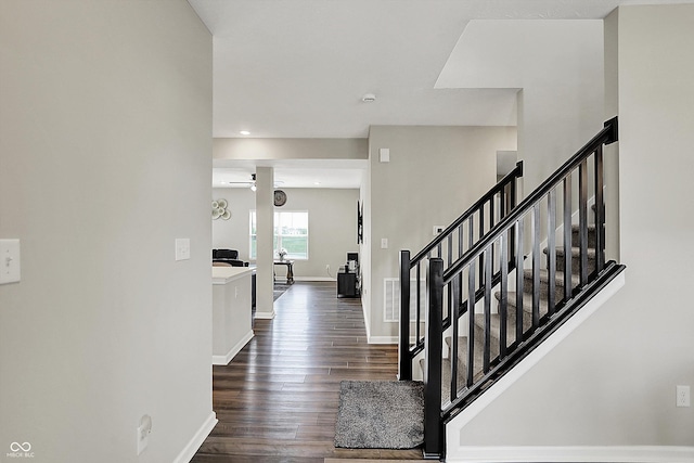 foyer entrance featuring dark wood-type flooring, baseboards, visible vents, and stairway