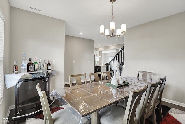 dining room with a notable chandelier, recessed lighting, baseboards, visible vents, and wood finished floors