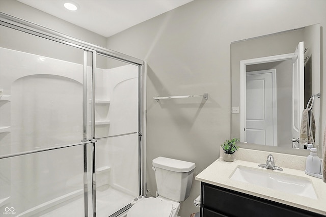 bathroom with vanity, toilet, and a shower stall