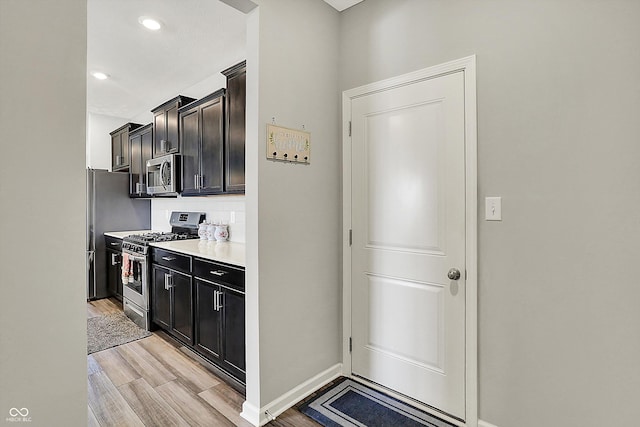 kitchen featuring light countertops, appliances with stainless steel finishes, baseboards, and light wood-style floors