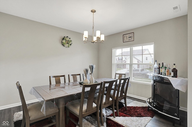 dining space with visible vents, an inviting chandelier, dark wood-style flooring, a bar, and baseboards