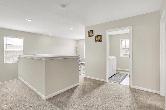 interior space with separate washer and dryer, carpet, baseboards, and plenty of natural light