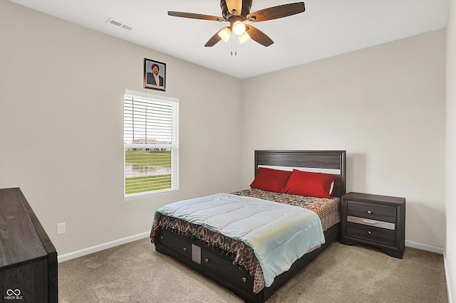 carpeted bedroom featuring baseboards, a ceiling fan, and visible vents