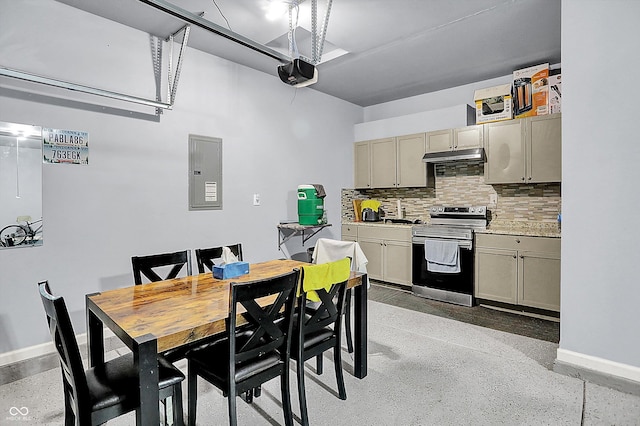kitchen with electric panel, backsplash, light countertops, stainless steel electric range oven, and baseboards