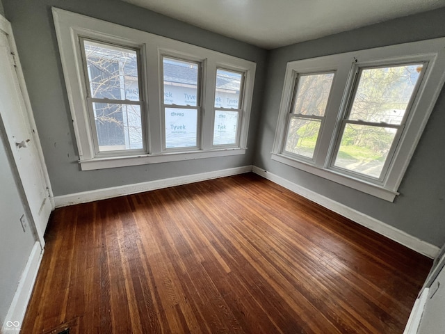 empty room with baseboards and dark wood-style flooring