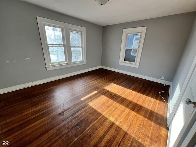 empty room featuring wood finished floors and baseboards