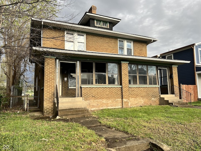 american foursquare style home featuring a gate, fence, a front yard, brick siding, and entry steps