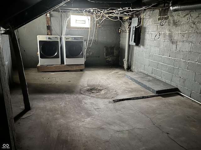 basement with electric panel and washing machine and clothes dryer