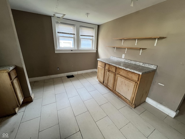 kitchen with baseboards, brown cabinets, and open shelves