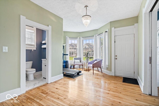 925 S State Ave, Indianapolis, IN 46203 - foyer entrance featuring baseboards, a chandelier, wood-type flooring, plenty of natural light, and a textured ceiling