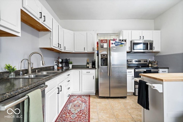 925 S State Ave, Indianapolis, IN 46203 - kitchen with stainless steel appliances, a sink, white cabinetry, and light tile patterned floors