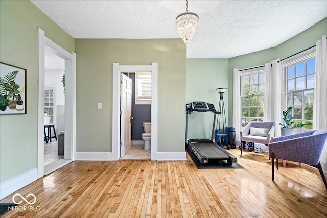 925 S State Ave, Indianapolis, IN 46203 - exercise room with hardwood / wood-style flooring, a chandelier, a textured ceiling, and baseboards