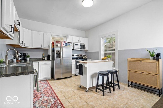 925 S State Ave, Indianapolis, IN 46203 - kitchen featuring stainless steel appliances, a sink, white cabinets, and dark countertops