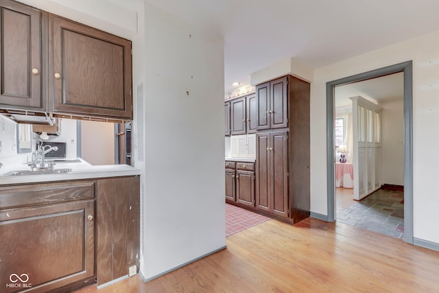 8903 Maple Hill Dr, Indianapolis, IN 46239 - kitchen with a sink, light wood finished floors, baseboards, and light countertops