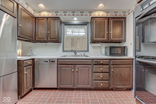 8903 Maple Hill Dr, Indianapolis, IN 46239 - kitchen featuring stainless steel appliances, a sink, light countertops, and brick patterned flooring
