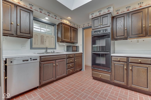 8903 Maple Hill Dr, Indianapolis, IN 46239 - kitchen with dishwasher, a sink, light countertops, brick patterned flooring, and recessed lighting