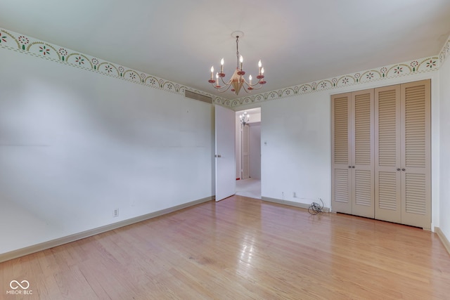 8903 Maple Hill Dr, Indianapolis, IN 46239 - empty room featuring a chandelier, wood finished floors, and baseboards