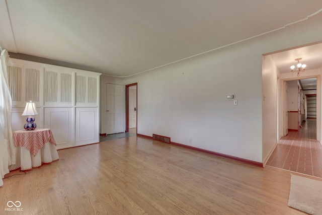 8903 Maple Hill Dr, Indianapolis, IN 46239 - empty room with a chandelier, light wood-type flooring, and baseboards