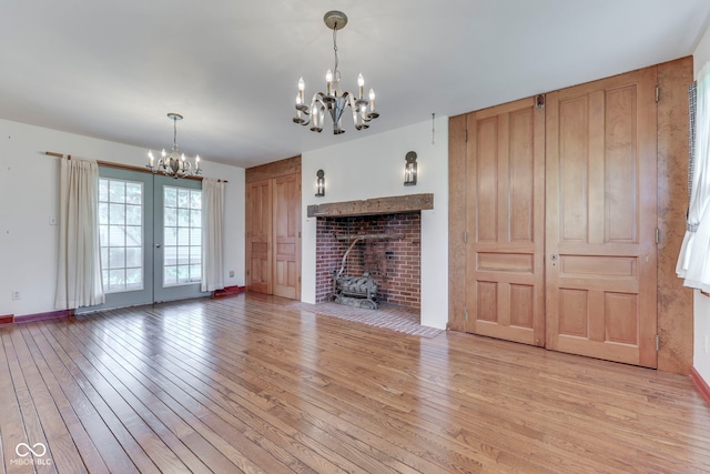 8903 Maple Hill Dr, Indianapolis, IN 46239 - unfurnished living room with a chandelier, light wood finished floors, baseboards, and french doors