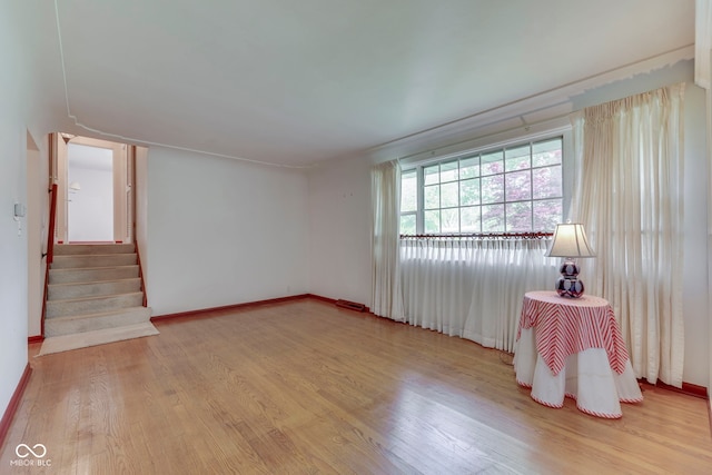 8903 Maple Hill Dr, Indianapolis, IN 46239 - empty room with wood finished floors, baseboards, and stairs
