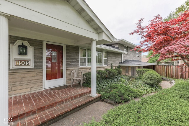 8903 Maple Hill Dr, Indianapolis, IN 46239 - property entrance featuring a porch, fence, and stone siding
