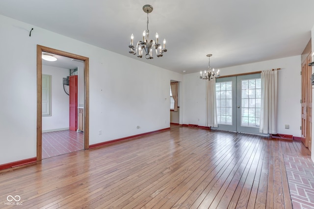 8903 Maple Hill Dr, Indianapolis, IN 46239 - unfurnished room featuring a chandelier, wood-type flooring, baseboards, and french doors