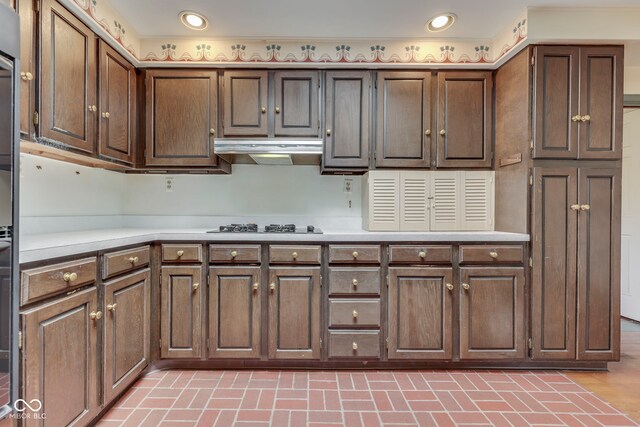 8903 Maple Hill Dr, Indianapolis, IN 46239 - kitchen with light countertops, under cabinet range hood, gas cooktop, brick patterned floors, and recessed lighting