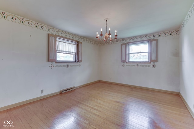 8903 Maple Hill Dr, Indianapolis, IN 46239 - spare room with a chandelier, light wood-type flooring, and baseboards