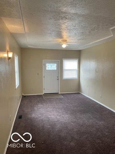 entrance foyer with baseboards, carpet floors, and a textured ceiling