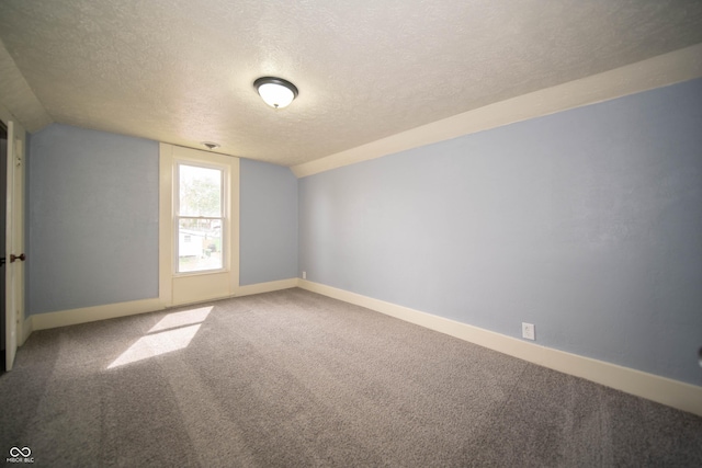 spare room featuring a textured ceiling, baseboards, and carpet floors