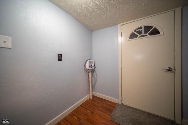 interior space featuring a textured ceiling, baseboards, and wood finished floors
